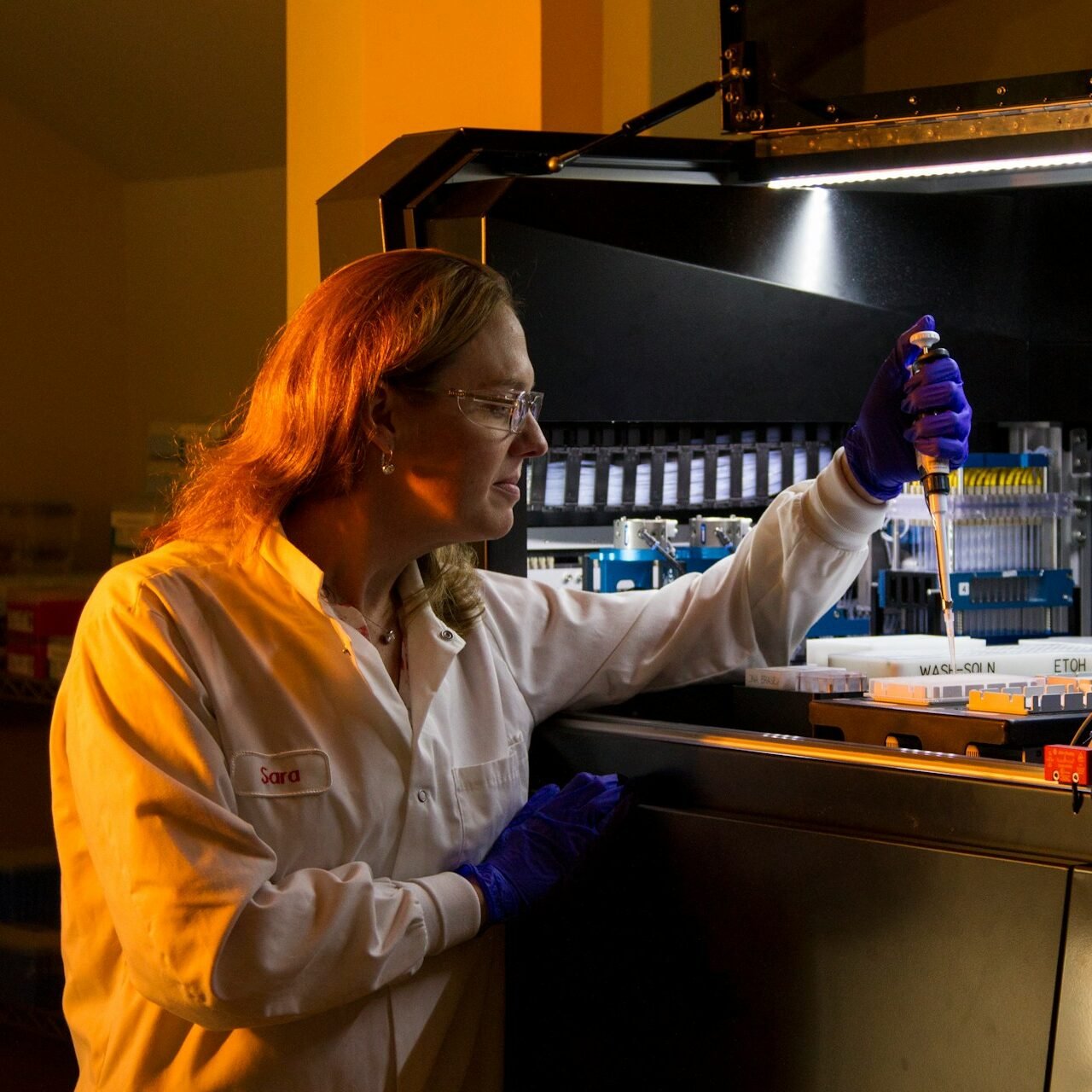 Home 4 a woman in a lab coat holding a pipette